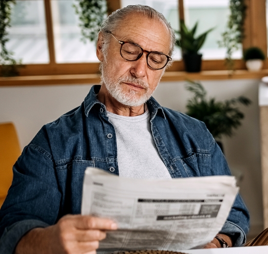 Älterer Herr liest mit seiner Lesebrille Zeitung. 